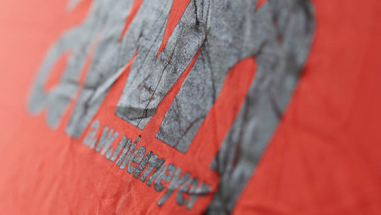 Nahaufnahme des aufgedruckten Logos „awn a.w. niemeyer“ auf einem roten, leicht zerknitterten Stoff – vermutlich eine Rettungsweste.